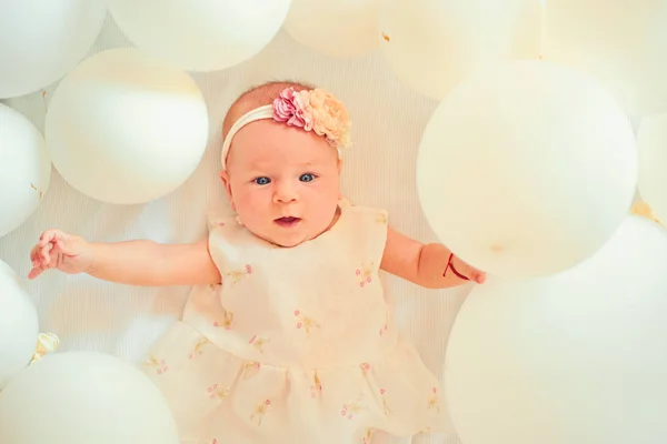 It is out future baby. Small girl. Happy birthday. Sweet little baby. New life and birth. Portrait of happy little child in white balloons. Family. Child care. Childrens day. Childhood happiness