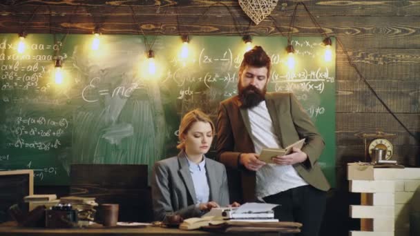 Frau druckt Text auf Schreibmaschine unter dem Diktat eines bärtigen Mannes im Hintergrund einer grünen Schultafel. Schreibmaschinenarbeiterin in der Schule. Schreibmaschine im Retro-Stil und sexy Sekretärin. — Stockvideo