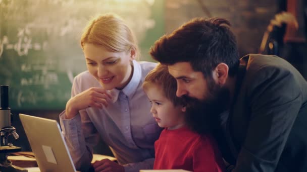 Familie mit Laptop zu Hause. glückliche junge Familie beim gemeinsamen Zeichentrickgucken auf dem Laptop. glückliche Familienzeit. Familienkonzept. — Stockvideo