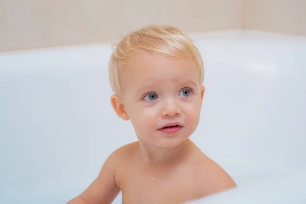Маленька дитина миє бульбашками. Щасливий малюк приймає ванну, граючи з матір'ю і піною . — стокове фото