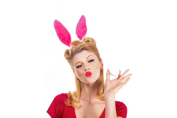 Easter egg hunting - Easter day concept. Isolated white background. Pin up Easter. Bunny ears concept. Woman wearing a mask Easter bunny and looks very sensually. Hunting eggs.