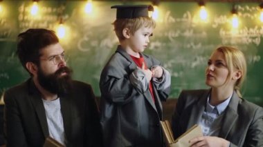 Büyük takım elbise ceket ve mezuniyet şapkalı çocuk. Eğitim İlköğretim Okulu'nda. Profesyonel öğretmenler kendi akademik içerik konusunda uzmanız. Eğitim ve okul kavramı. Öğretmen ve öğrenci. Okula dönüş.