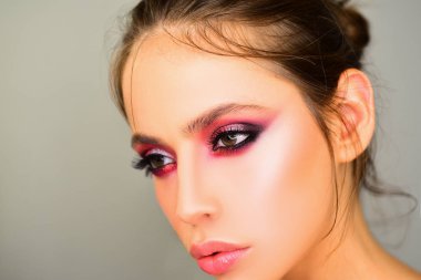 Stüdyoda gri arka planda güzel bir kadın var. Yakın plan portre. Moda, güzellik, kozmetik. Makyaj, pürüzsüz cilt.