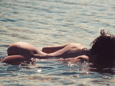 Şehvetli kadın seksi vücut ile kumsalda sakin ol. çıplak kız kalça deniz suyu ile. Seks oyunları ve baştan çıkarma. Seksi kadın okyanusta yüzmek. Yaz tatili ve cennet tatil seyahat