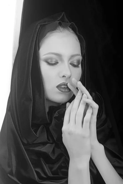 Black Friday concept. Gothic fashion and beauty. Fashion model with makeup of mysterious girl. Sexy madonna woman in black hood. Makeup look and skincare sensual of girl. Religion and death concept.