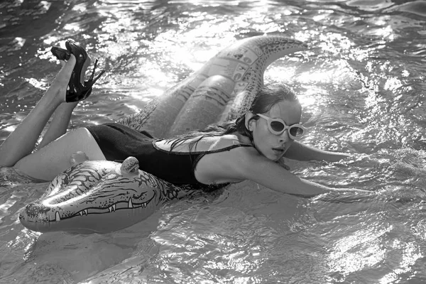 Piscina con mujer joven en piel de cocodrilo zapatos. piscina con chica en cocodrilo inflable —  Fotos de Stock