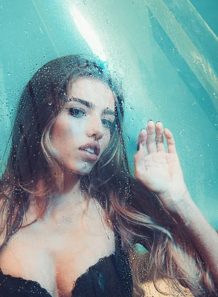 Regnet droppar på fönsterglas med ansikte av flicka. regnet droppar på glas och sexig kvinna lich dem med tungan. — Stockfoto