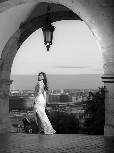 Bellezza donna in abito bianco sulla vista della città. Modello di bellezza con capelli lunghi sul balcone — Foto Stock