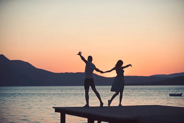 Couple dansant à la plage par une journée ensoleillée au coucher du soleil . — Photo