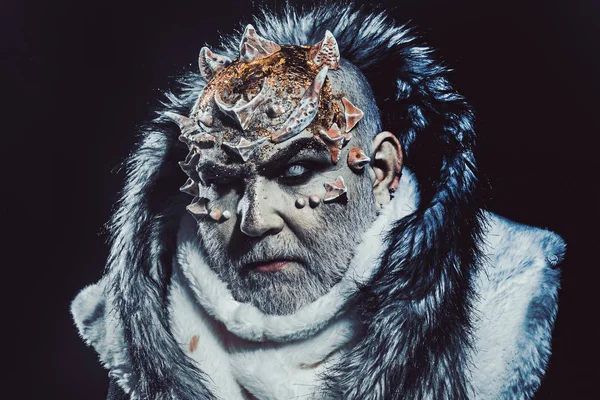 Dark arts concept. Senior man with white beard dressed like monster. Demon on black background, close up. Man with thorns or warts in fur coat. Alien, demon, sorcerer makeup — Stock Photo, Image