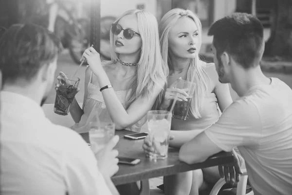 Група партійних людей, дві пари з коктейлями в барі — стокове фото
