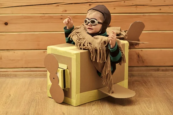 Niño pequeño jugar en avión de cartón, la infancia . — Foto de Stock