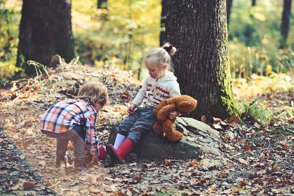 Kleiner Bruder kümmert sich um kleine Schwester im Herbst-Stadtpark — Stockfoto