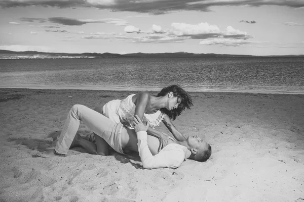 Sexe sur la plage concept. Couple plein de désir avoir des relations sexuelles sur le sable du bord de mer. Amoureux sensuels faisant l'amour au bord de la mer, mer en arrière-plan. Couple amoureux avoir des relations sexuelles, fait l'amour sur la plage de sable . — Photo