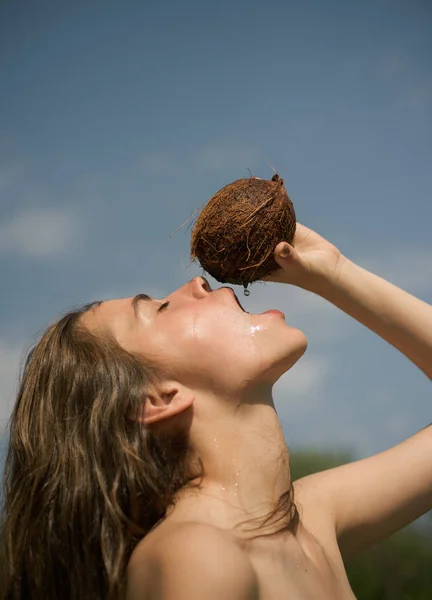 Produzione di olio di cocco. donna che beve succo di cocco. vacanze estive. cocktail sulla spiaggia. latte di cocco. Dieta alimentare pulita, vegetariana e vegana. vasca estiva o doccia esterna — Foto Stock