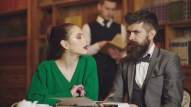 Güzel genç çift konuşmak ve kitaplık Kitaplığı'nda yakınındaki siting gülümseyerek. Genç öğrenciler kütüphanede. Öğrenciler Kütüphane Kampüsü eğitim bilgi kavramı. öğrencilerin kütüphanede.