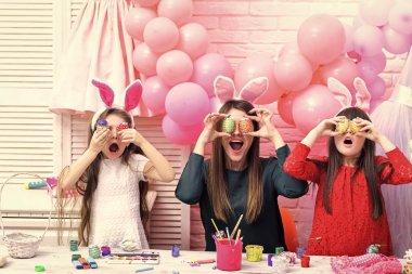 Bir anne ve kızları boyama yumurtalar.