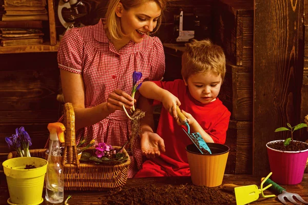 Bahçe kavramı. Küçük bir çocuk yardım Anne Bahçe aracı ile tencerede çiçek dikim. Organik Bahçecilik. Bahçe kalp işi