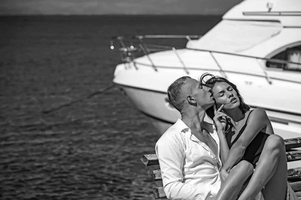 Ativo casal na praia relaxar perto de iate de luxo no banco . — Fotografia de Stock
