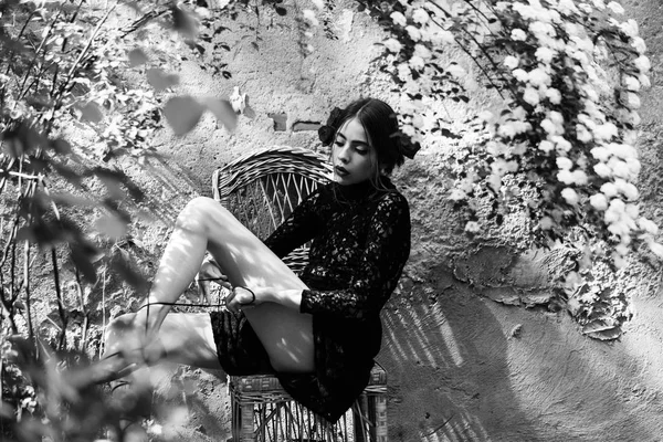Frau bindet an sonnigem Tag Schnürsenkel auf Korbstuhl — Stockfoto