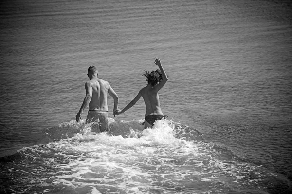 Szexi test szerelmes pár strandon pihenhetnek. Nyaralás és a paradicsom utazás nyaralás. Szexi nő és férfi fut a víz. Szeretem a boldog meztelen pár tengeri kapcsolatok. Család és a Valentin-nap. — Stock Fotó