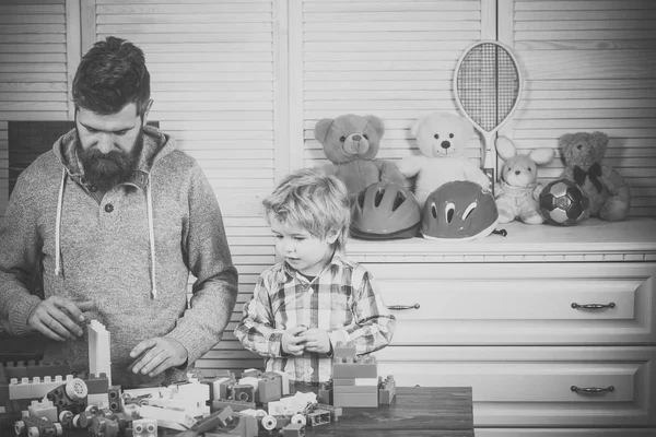 Family play with construction plastic blocks. Father and son play