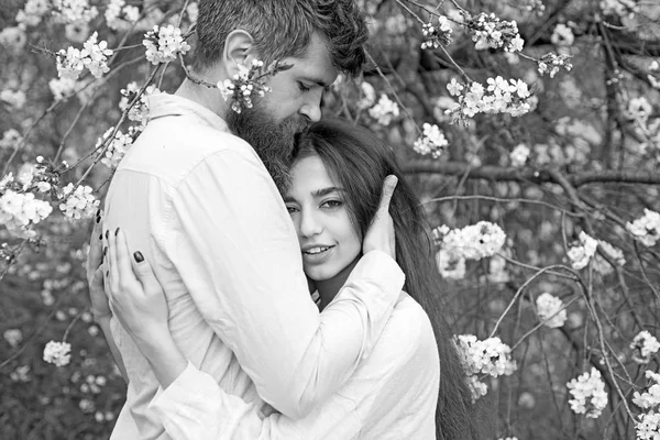 Couple amoureux passer du temps dans le jardin de printemps, branches avec des fleurs sur le fond. Concept de rendez-vous du printemps. Câlins de couple près des arbres en fleurs. homme et femme câlins dans le jardin en fleurs le jour du printemps . — Photo