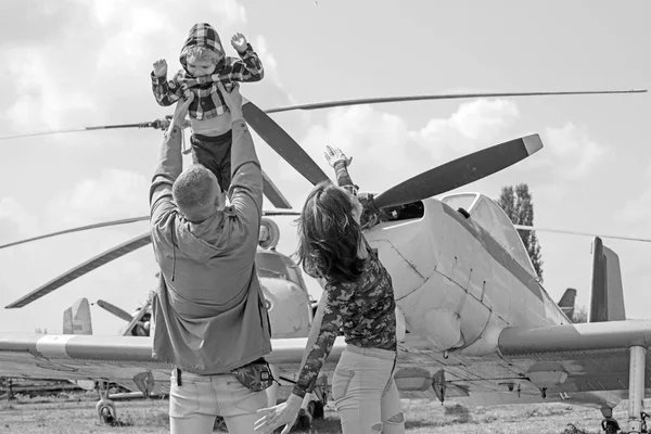 Flying like a bird. Woman and man with boy child at helicopter. Happy family vacation. Family couple with son on vacation travel. Air tour and travel. Enjoying travelling by air