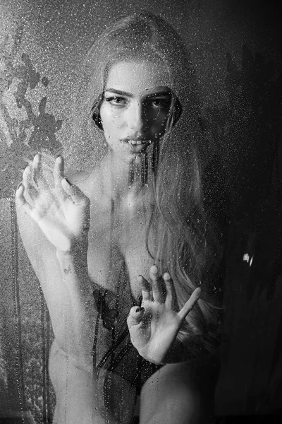 Window with water drops before girl with makeup. Shower and hygiene spa treatment. Rain drops on window glass in heart shape. Fashion beauty and love. Sexy woman behind plastic sheet with water drops — Stock Photo, Image