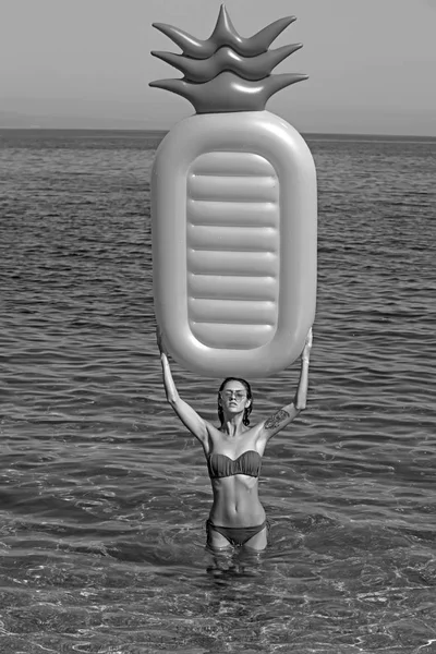 Maldives ou Miami plage d'eau. Fille bronzer sur la plage avec matelas gonflable. Matelas gonflable ananas, activité et joie. Femme sexy sur la mer des Caraïbes aux Bahamas. Vacances d'été et voyage à l'océan . — Photo