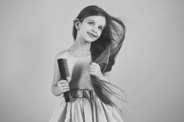 Porträt eines lächelnden kleinen Mädchens, das sich die Haare bürstet — Stockfoto