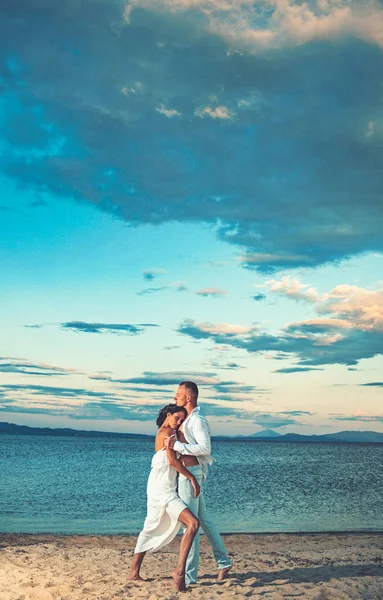 Um abraço na praia. Jovem casal feliz andando na praia ao redor uns dos outros . — Fotografia de Stock