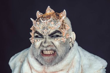 Siyah arka plan, cehennemdeki şeytanlar kapatın. Dikenler veya siğiller kürk paltolu adam. Uzaylı, iblis büyücü makyaj. Karanlık sanatlara kavramı. Kızgın yüz beyaz sakallı komuta sizde canavar gibi giyinmiş.