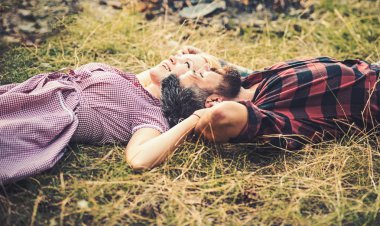 Çim üzerinde yalan ve gökyüzüne bakarak yan görünümü çift. Park veya orman genç insanlar rahatlatıcı. Yaz tatil Romantik