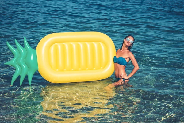 Colchón inflable de piña, actividad y alegría. colchón de aire de piña y mujer sexy en agua de mar . — Foto de Stock