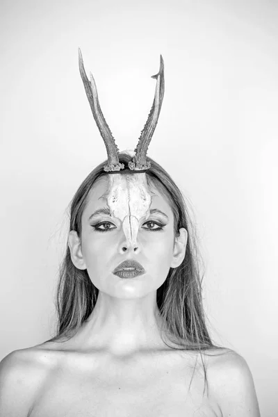 Beauty of woman with animal skull and antlers. Beauty look and cosmetics for skincare.