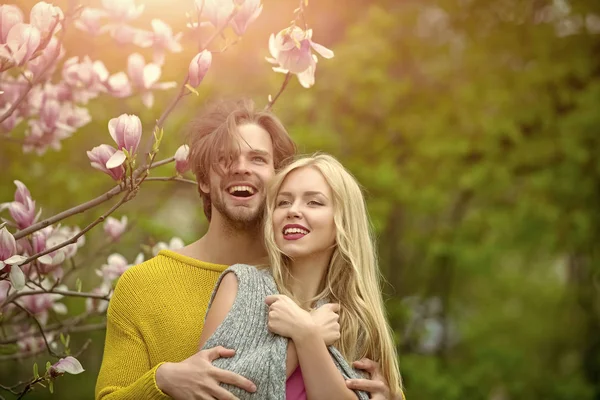 Мужчина и женщина, влюбленная пара в весенние цветы магнолии — стоковое фото