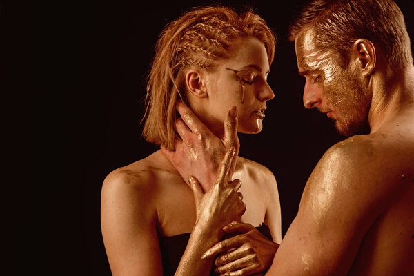 Золотая маска и красота коллагена. 24K Gold. Золотой спа и лечение кожи. Сексуальная пара с золотым макияжем, изолированным на черном. Отношения между мужчиной и женщиной. Эротические игры влюблённых пар
.