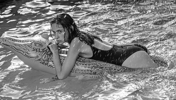 Aventuras de menina em crocodilo. Relaxe na piscina de luxo. mulher no mar com colchão inflável. Férias de verão e viagens para o oceano, maldivas. Moda couro de crocodilo e menina na água . — Fotografia de Stock