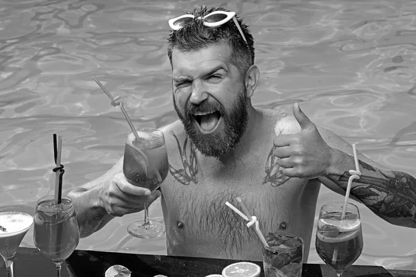 鸡尾酒和水果在游泳池里的大胡子男人。暑假的鸡尾酒会. — 图库照片
