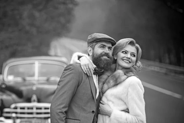 Жорстокий бородатий чоловік з вусами з дівчиною біля ретро-машини — стокове фото