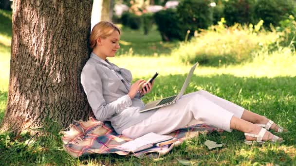 Oficina de medio ambiente natural. Beneficios de trabajo al aire libre. Mujer con ordenador portátil de trabajo al aire libre. Tecnología educativa y concepto de internet. Chica trabajar con el ordenador portátil en el parque sentarse en la hierba. Educación en el parque . — Vídeos de Stock