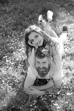 Gülümseyen yüzler doğa üzerinde arka plan açık havada, Sigara çift. Erkek ve kadın üzerinde çim döşeme bahar günü. Sigara alışkanlığı kavramı. Aşık çift harcamak zaman açık havada ve yasaktır.