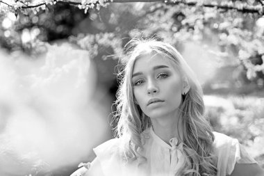 Genç kadın kadar çiçek Bahçe, ufuk, yakın zevk. Bahar bloom kavramı. Bayan Park bahar gününde. Rüya gibi yüz, Erguvan, Doğa arka plan mor çiçekler yakınındaki ihale sarışın kız.