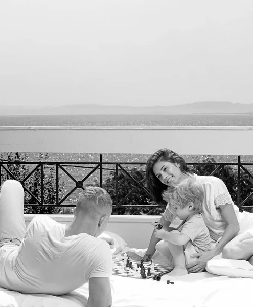 Vater und Mutter mit Sohn spielen Schach, während sie Zeit zu Hause verbringen. — Stockfoto