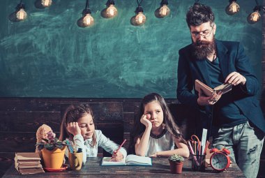 Öğretmen ve okuma çocuklar ilköğretim okulunda kitaplığındaki kitap