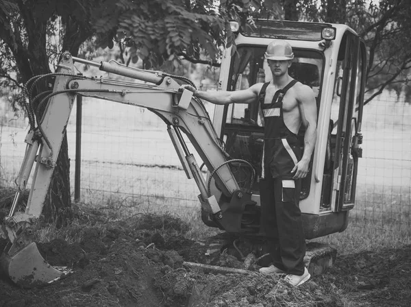 Sexy man with nude torso near construction equipment or excavator — Stock Photo, Image