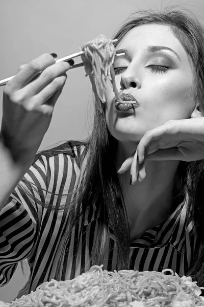 Una mujer de belleza come pasta para cenar. Modelo de belleza comer espaguetis con palillos —  Fotos de Stock