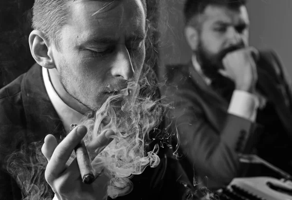 Thinking about problem solution. Thoughtful man smoking cigar. Businessmen hold business meeting. Business partners thinking together in office. Coworkers solving a business problem