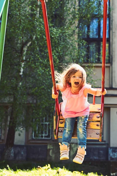 Δραστηριότητα του καλοκαιριού. Μικρό παιδί παίζει το καλοκαίρι. Ευτυχισμένος κορίτσι γέλιο παιδιού στην κούνια. παιδική ηλικία ονειροπόληση .teen ελευθερία. Ρομαντικό κοριτσάκι για τα swing, γλυκά όνειρα. Παιδική χαρά στο πάρκο — Φωτογραφία Αρχείου